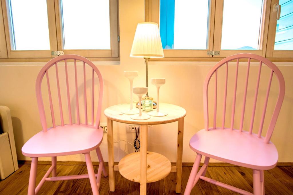 two pink chairs sitting next to a table with a lamp at ECO Aparthotel The Dreamers's Club in Lumbarda