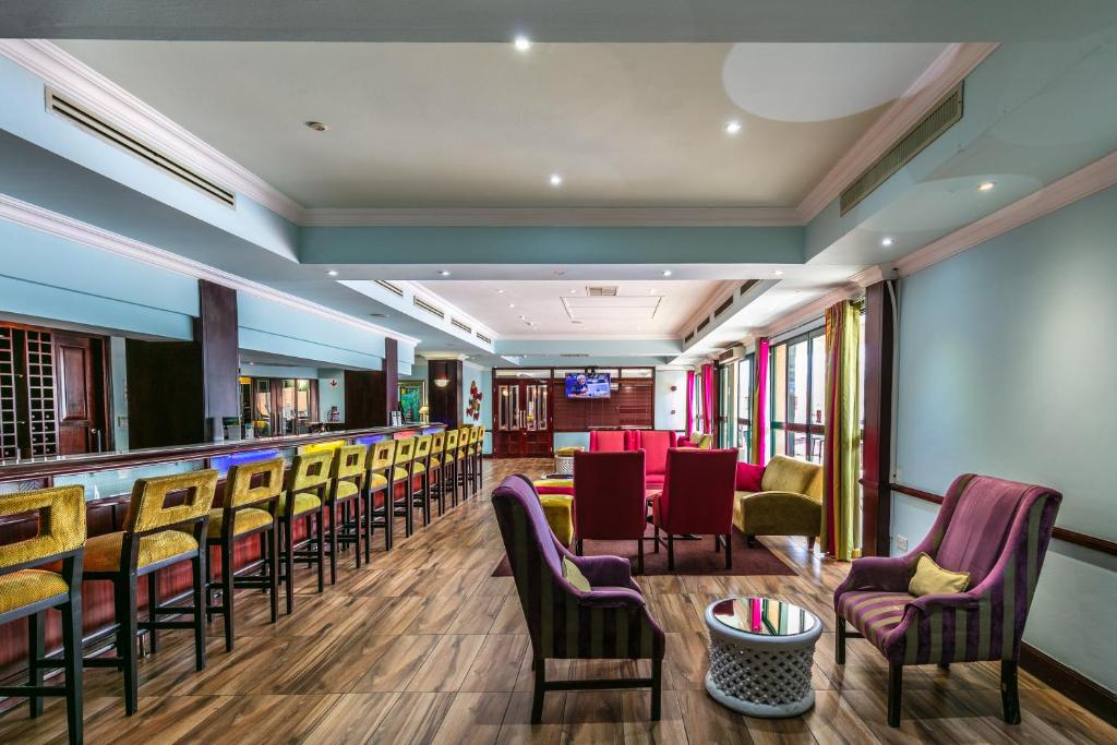 Cresta President Hotel في غابورون: وجود بار في المطعم مع الكراسي والطاولات