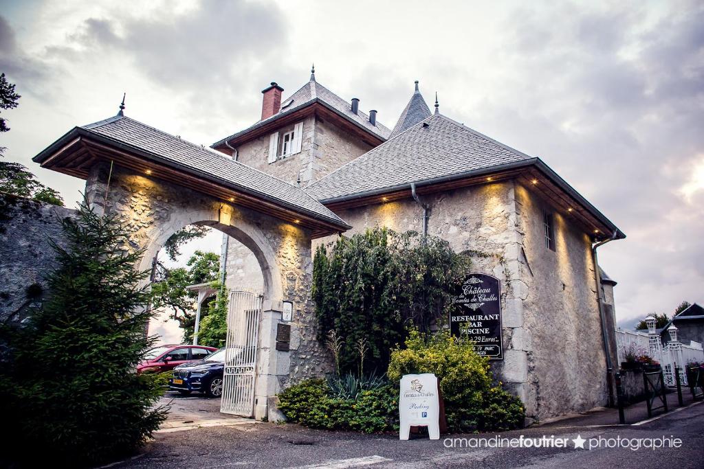 un bâtiment avec un panneau devant lui dans l'établissement Château des Comtes de Challes, à Challes-les-Eaux