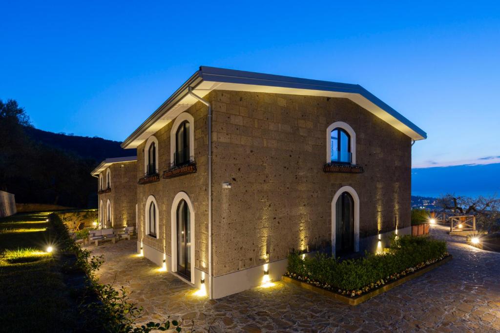 un grand bâtiment en briques avec des lumières devant lui dans l'établissement Maison Bon Bon, à Sorrente