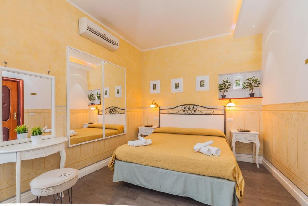 ein Schlafzimmer mit einem Bett und einem großen Spiegel in der Unterkunft Albergo Della Corte in Benevento