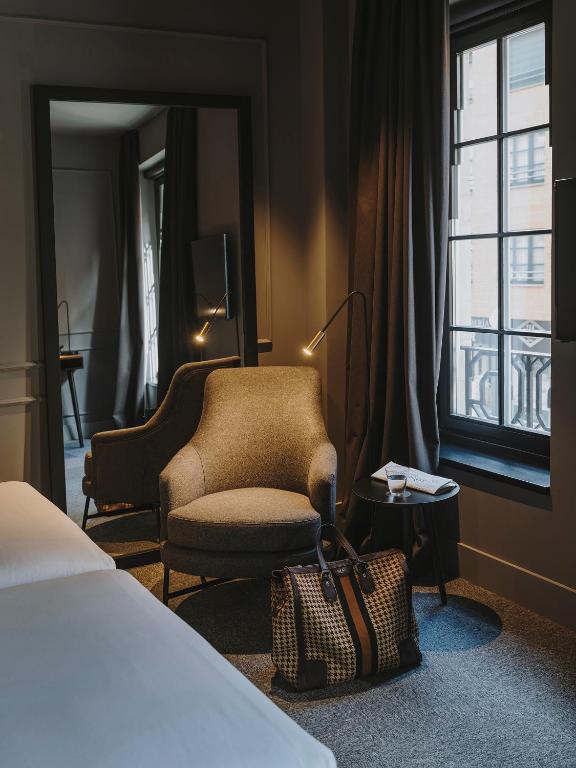 a hotel room with a chair and a chair at El Môderne Hotel in Gijón