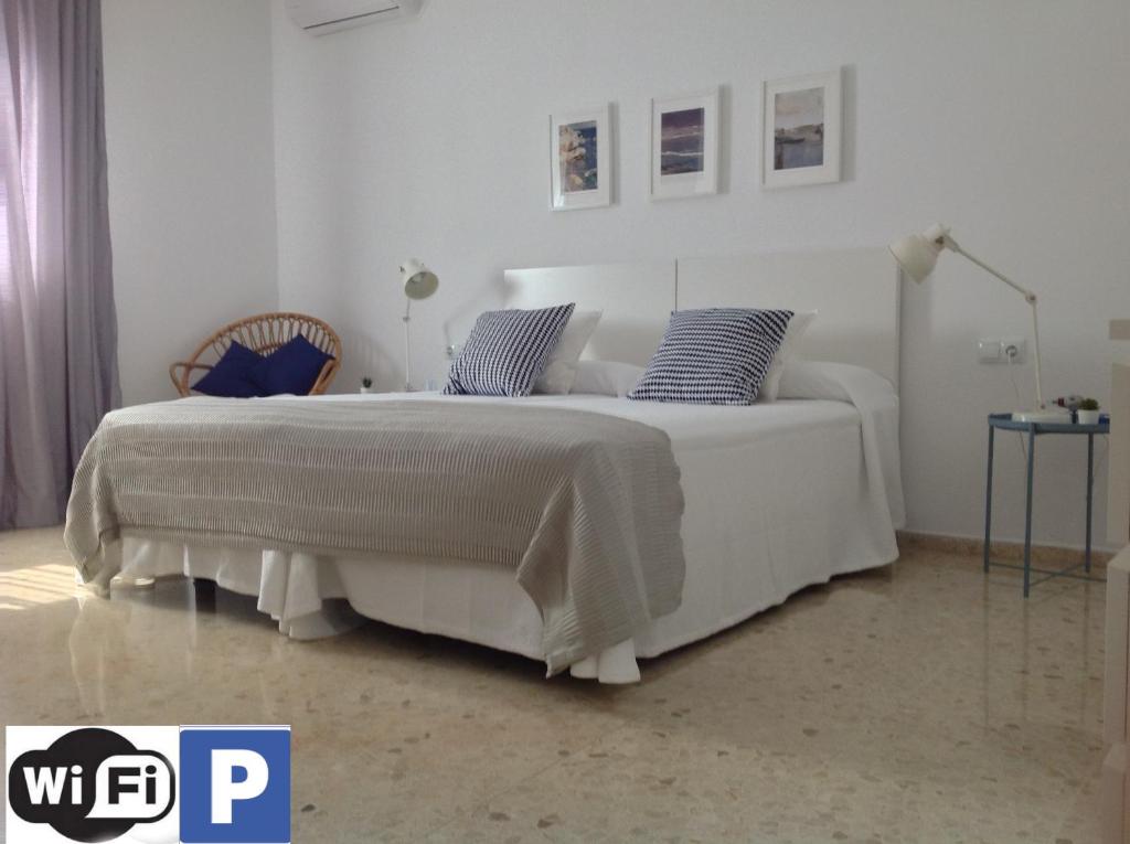 カディスにあるLa Despedidaのベッドルーム(青い枕の大きな白いベッド付)