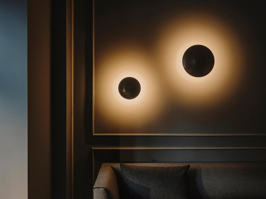 a pair of lights on a wall next to a couch at El Môderne Hotel in Gijón