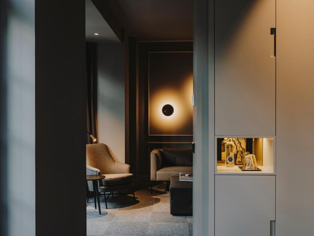 a living room with a chair and a mirror at El Môderne Hotel in Gijón