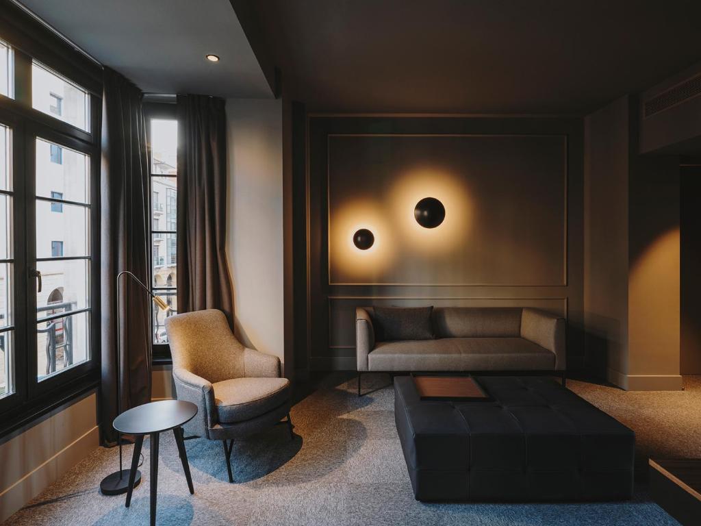 a living room with a couch and a chair at El Môderne Hotel in Gijón