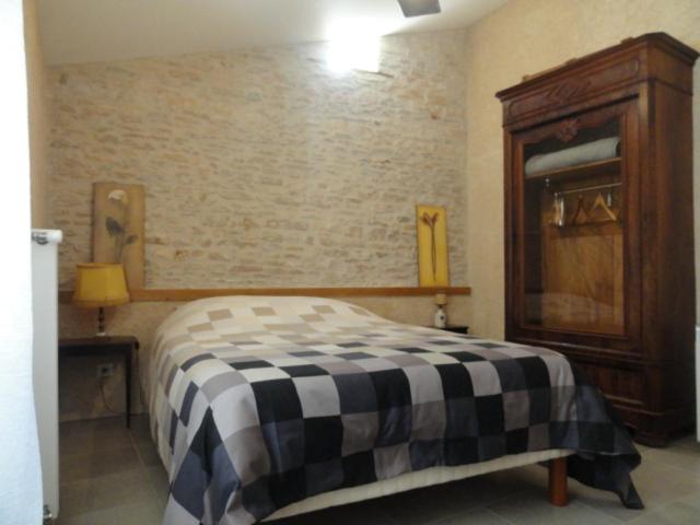 a bedroom with a bed and a wooden cabinet at Les chambres de Blanot in Blanot