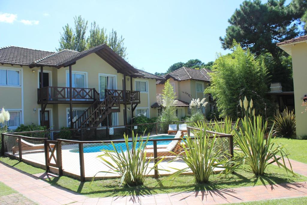 ein Haus mit einem Pool im Hof in der Unterkunft Apart Lawn Tennis Pinamar in Pinamar