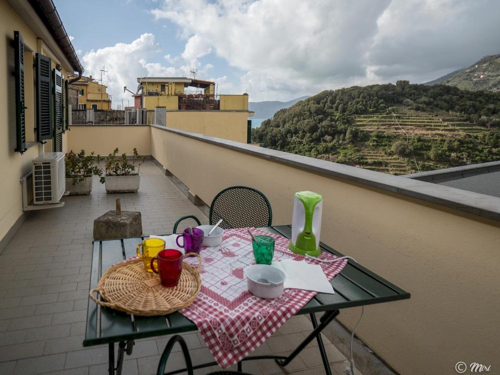 a table with cups and drinks on a balcony at Affittacamere Le Terrazze in Corniglia