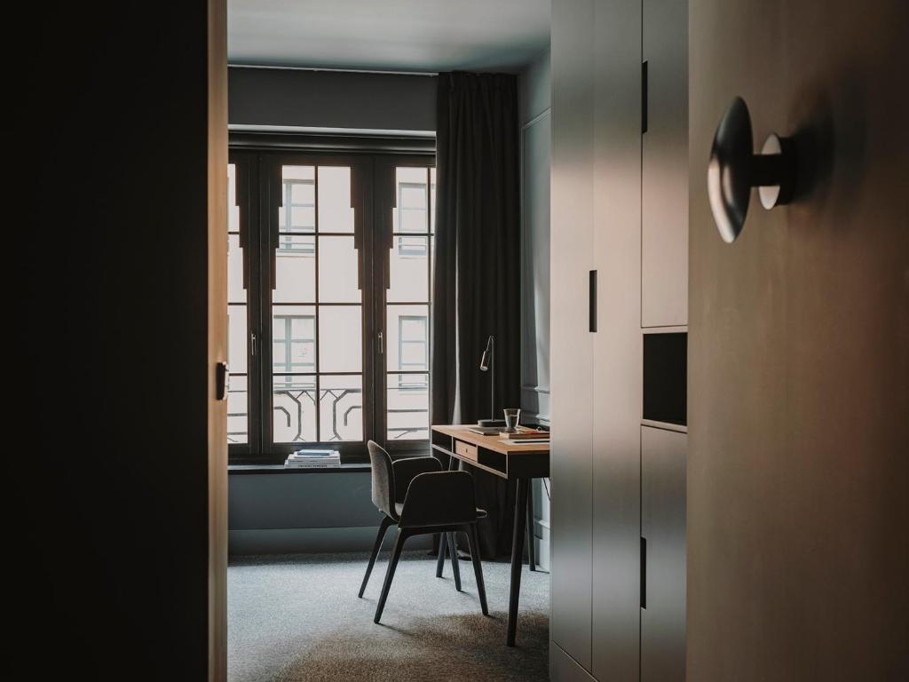 a room with a desk and a table with a chair at El Môderne Hotel in Gijón