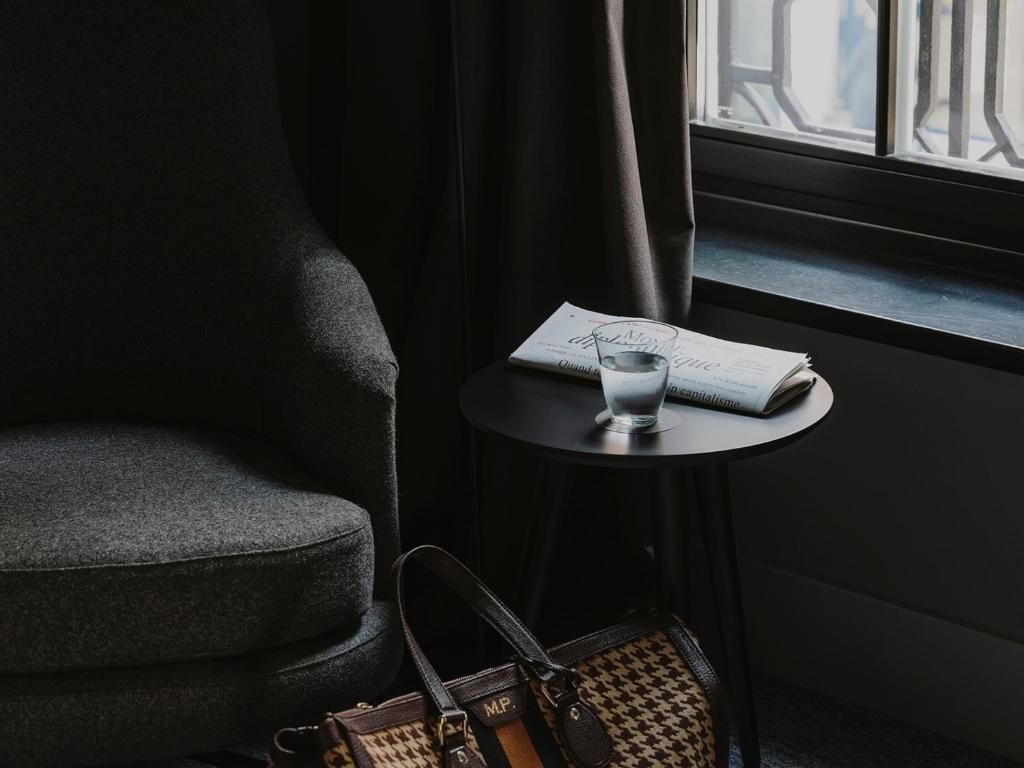 a glass of water on a table next to a window at El Môderne Hotel in Gijón
