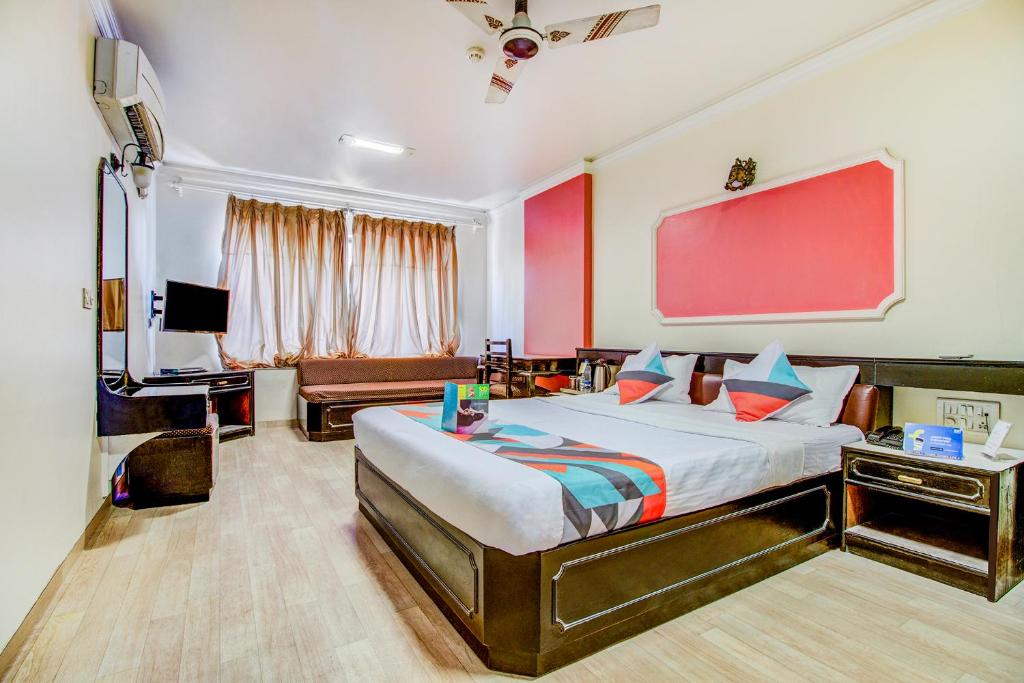- une chambre avec un lit et un mur rouge dans l'établissement Rutugandh Heritage, à Pune