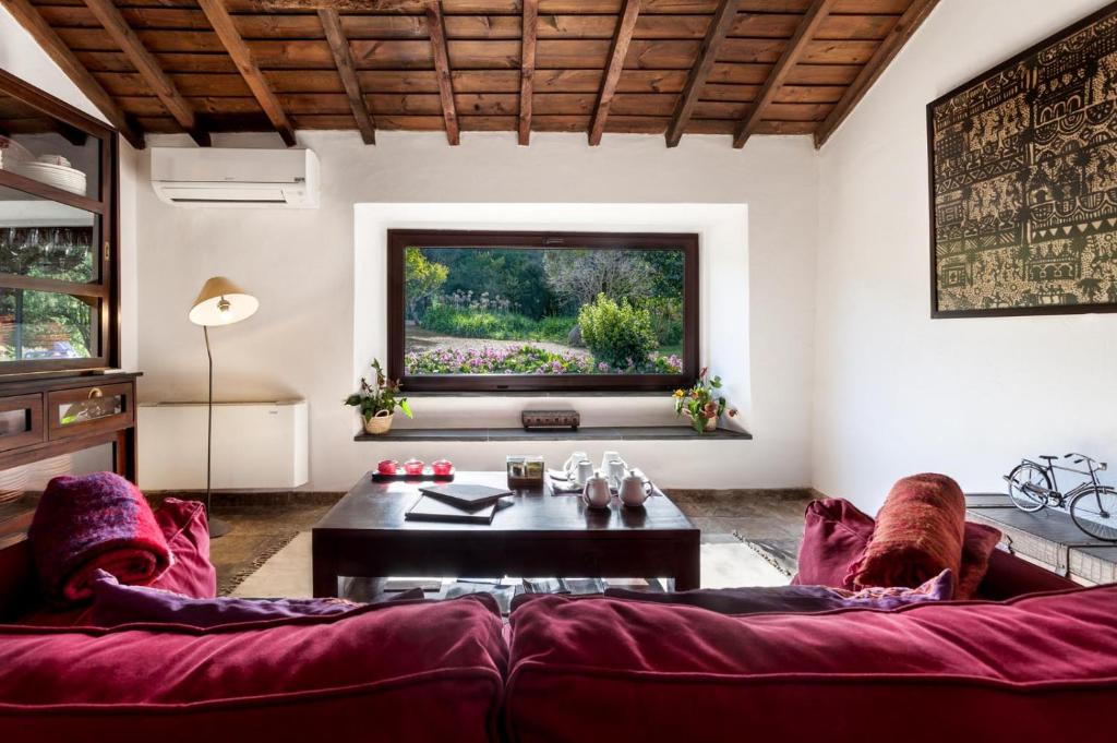 - un salon avec un canapé rouge et une table dans l'établissement Monte do Serrado De Baixo, à Évora