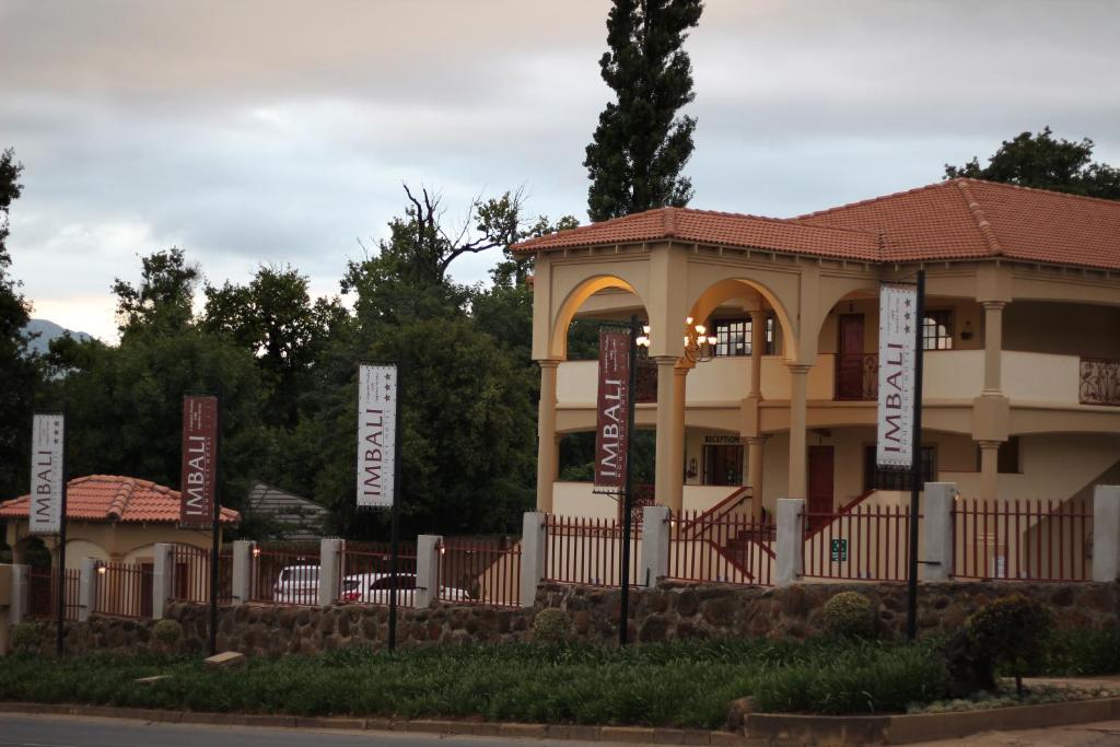 a building with signs in front of a fence at Imbali Boutique Hotel in Kokstad