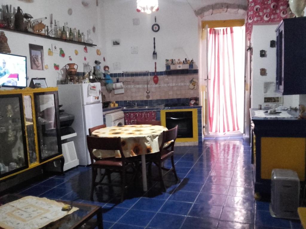 a kitchen with a table in the middle of a room at Appartamento in Carloforte