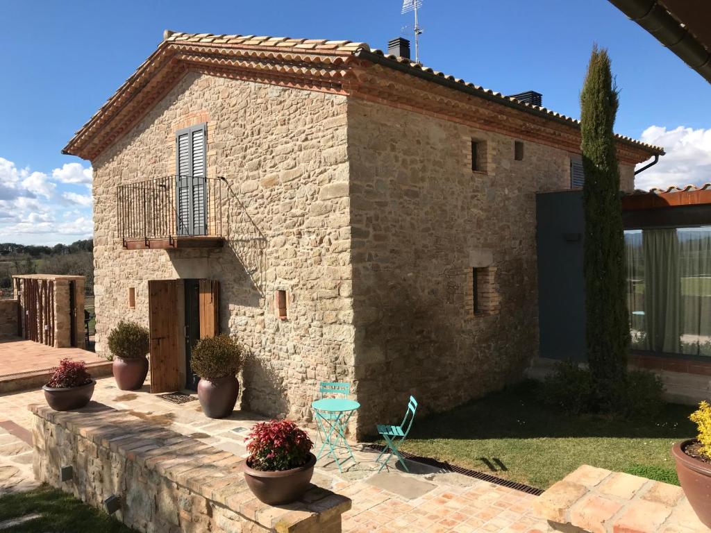 a stone house with potted plants in front of it at La Codina in San Bartolomé del Grau