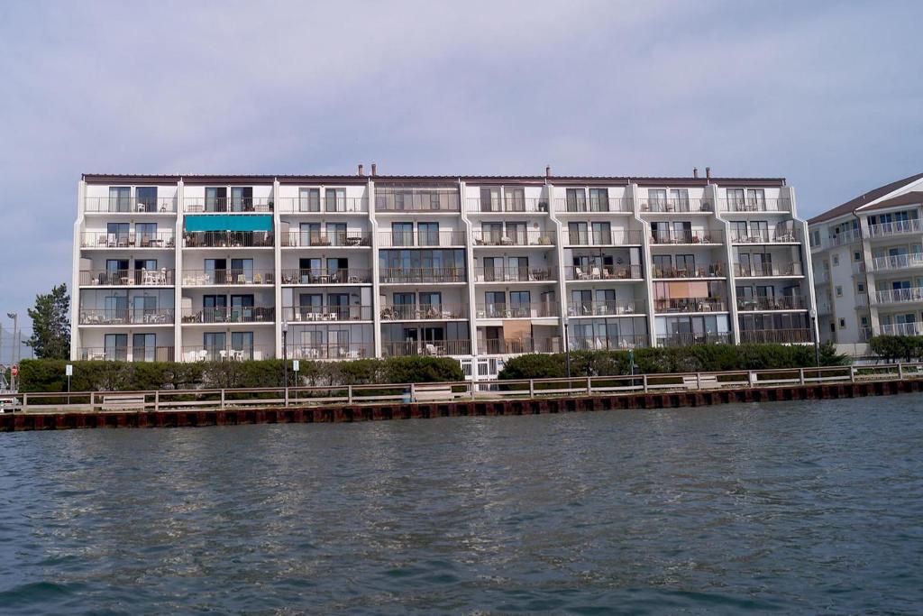 a large apartment building next to a body of water at Crab Cove On The Bay 406 in Ocean City
