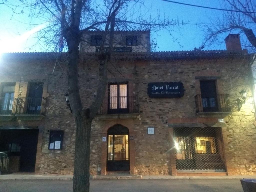 a brick building with a sign on the front of it at Hotel Villa de Berzocana in Berzocana