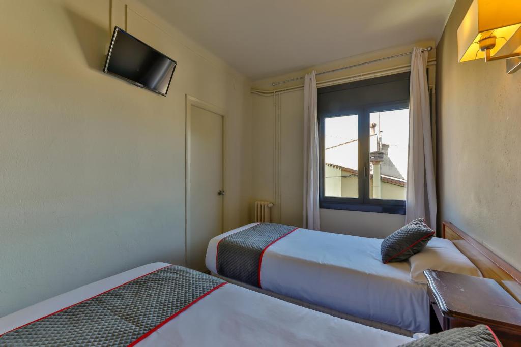 A bed or beds in a room at Hostal Alberana