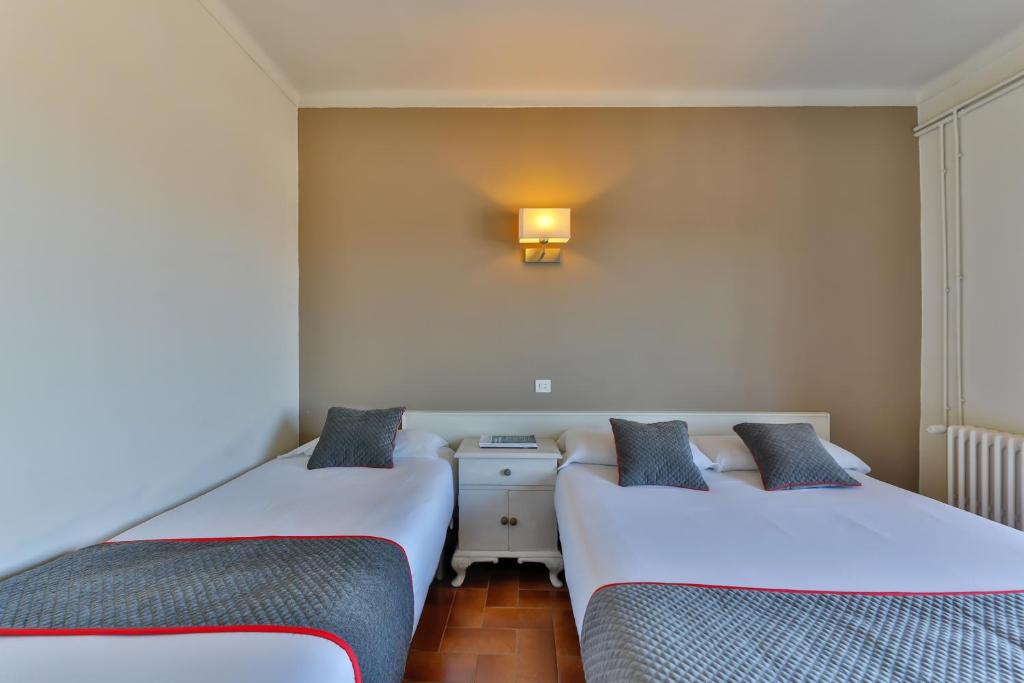 A bed or beds in a room at Hostal Alberana