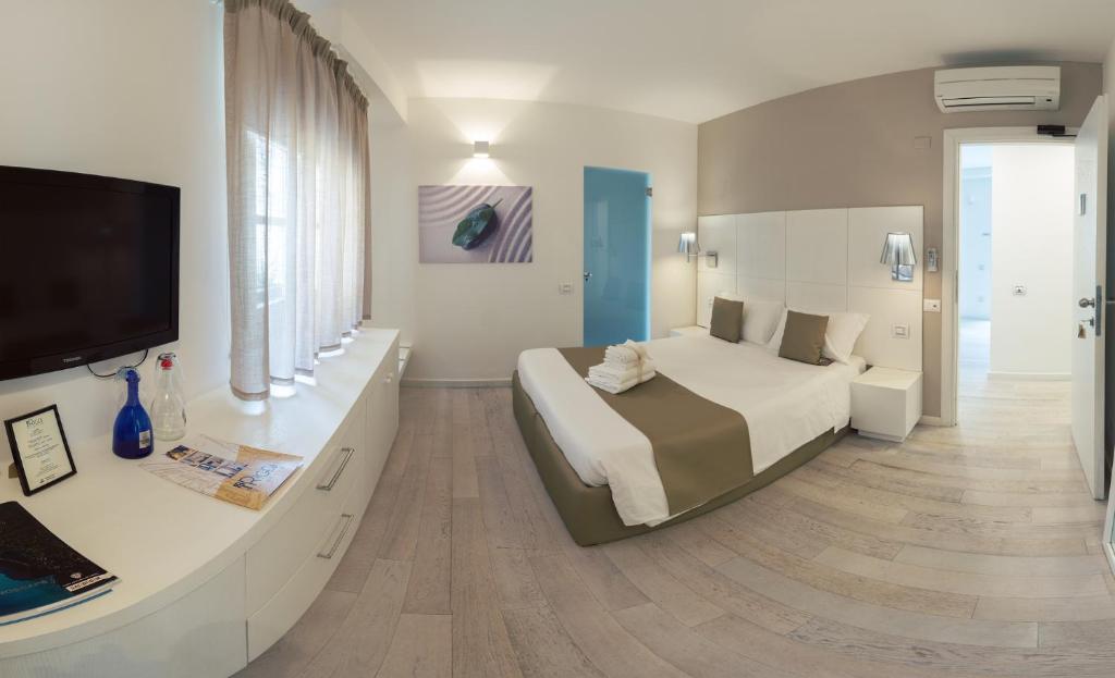 a bedroom with a bed and a flat screen tv at Rigel Villanova Rooms in Cagliari