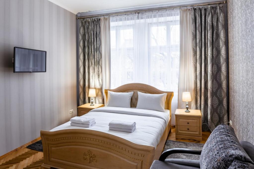 una camera con un grande letto e una finestra di Alfa Apartments Svobody 31 a Lviv
