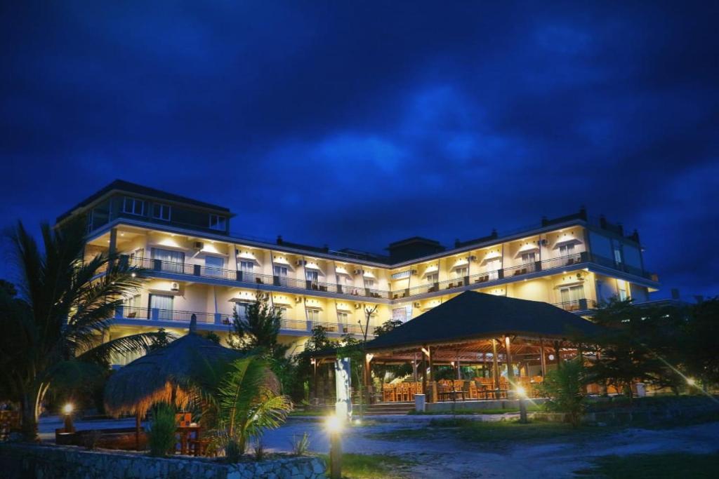 un gran edificio con luces delante de él por la noche en Padadita Beach Hotel, en Waingapu