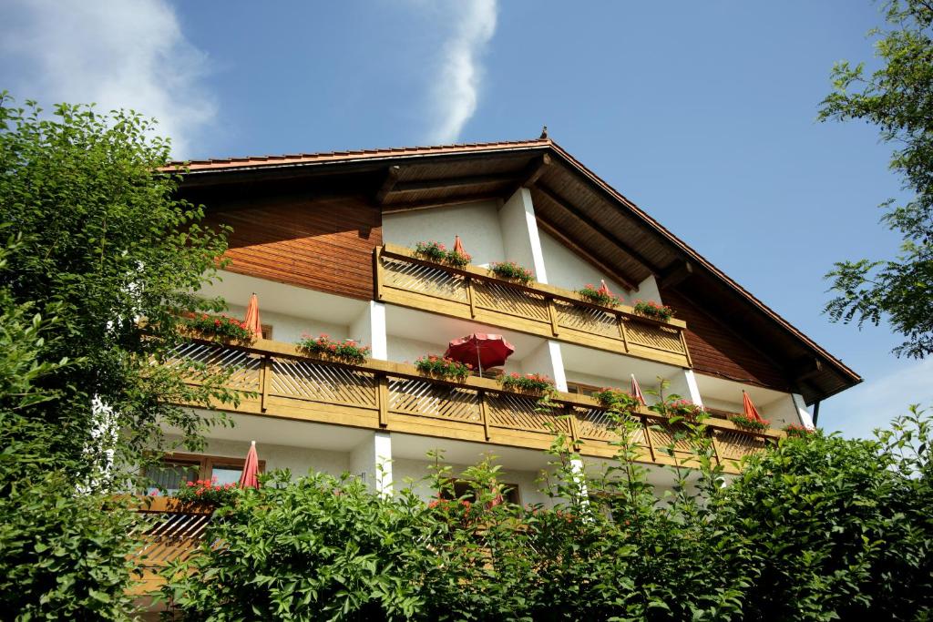 a building with a balcony with flowers on it at Appartementhaus Albrecht in Bad Füssing
