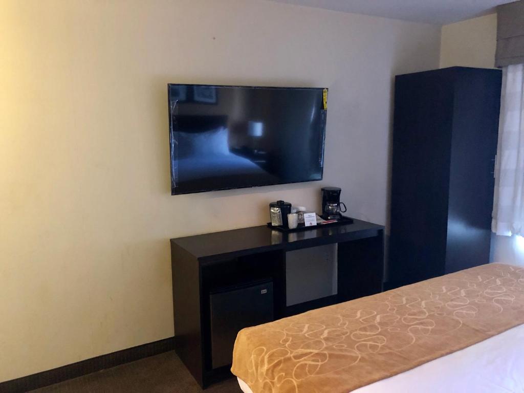 ブルックリンにあるThe Vue Inn Brooklynのテレビ、デスク、ベッドが備わる客室です。