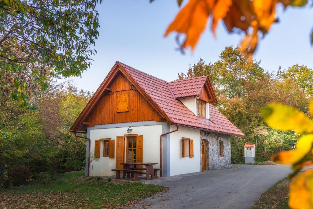 ein kleines Haus mit einem roten Dach und einem Picknicktisch in der Unterkunft Vineyard Cottage Vina in Medu in Trebelno