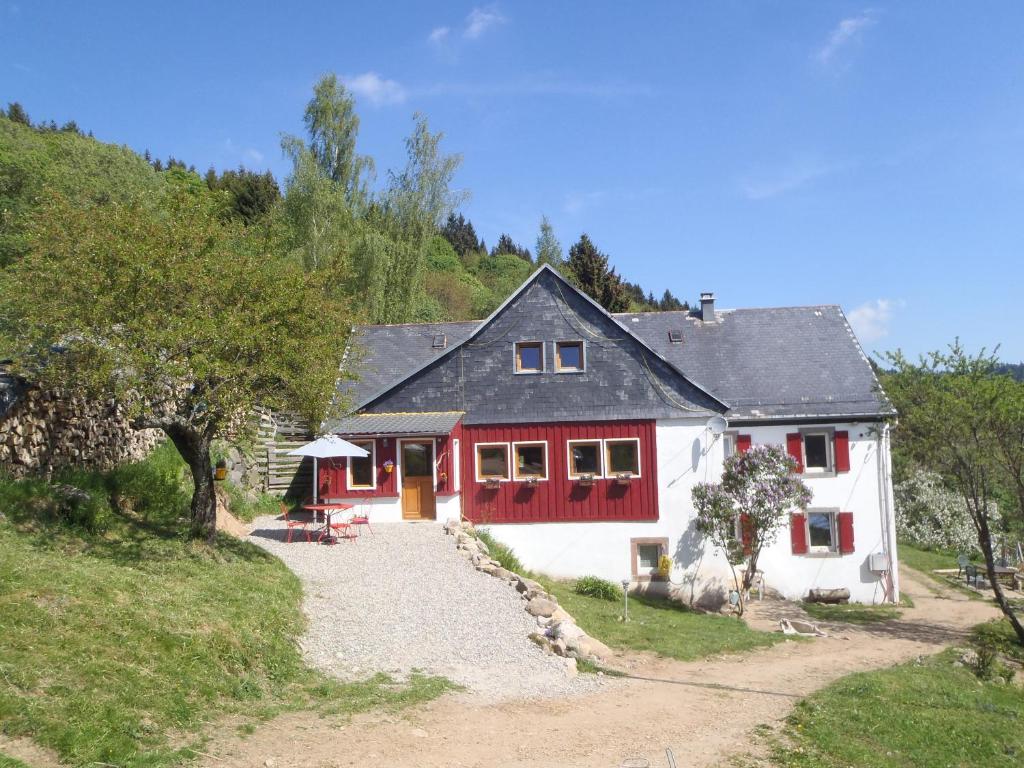 a large white house with red trim on a hill at La Petite Finlande in Orbey