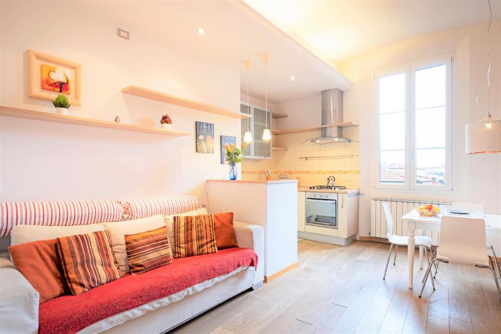 a living room with a couch and a kitchen at Skyline Central Apartment in Bologna