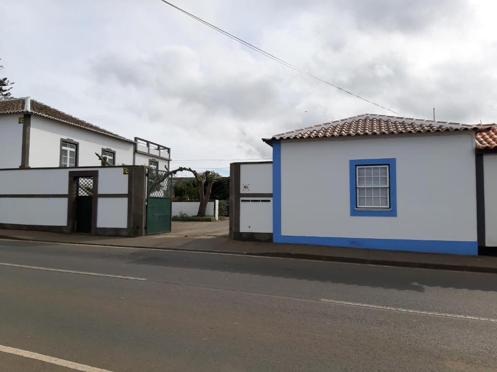 un edificio blanco y azul al lado de una calle en Alojamento Local de Santa Catarina, en Praia da Vitória