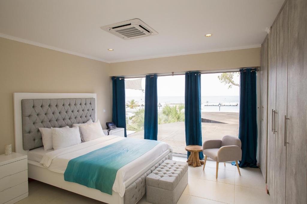 a bedroom with a bed and a view of the beach at Hotel Islander Bonaire in Kralendijk