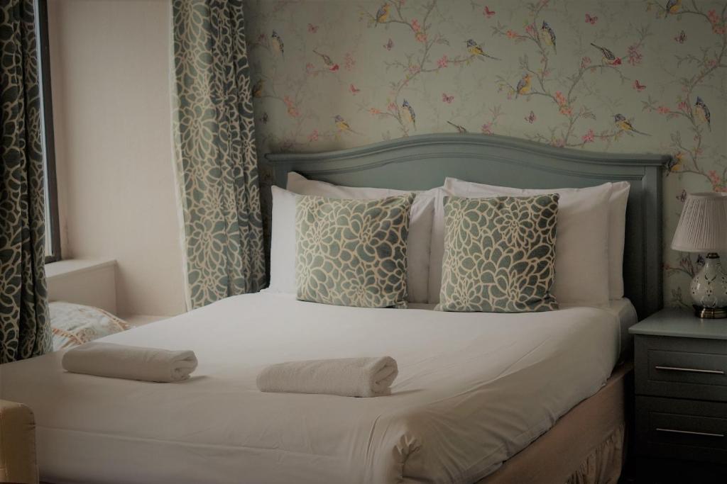 a bedroom with a bed with two towels on it at The Waterfront Townhouse Accommodation in Kilkenny