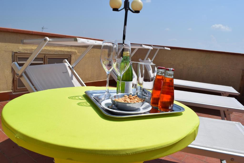 un tavolo verde con un piatto di cibo e bottiglie di vino di Eco-Hotel Edy a Chianciano Terme