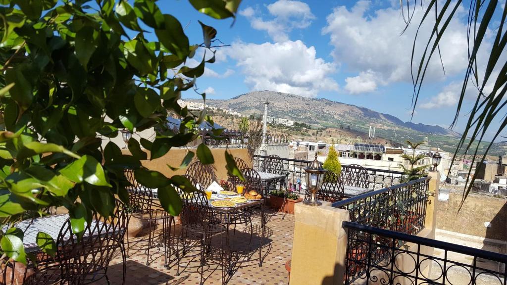 een patio met tafels en stoelen en een berg bij Dar Nour Fes in Fès