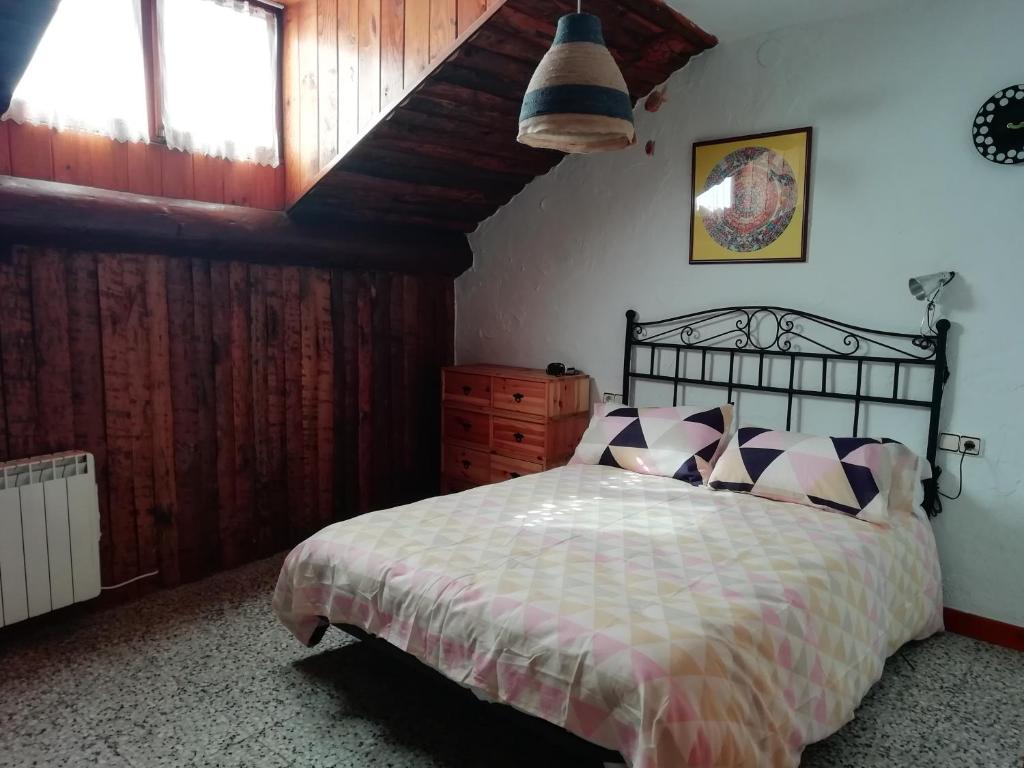 1 dormitorio con cama y techo de madera en Cal Jardiner, en Rialp