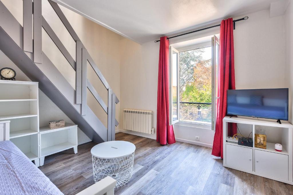 a living room with a bed and a window at Le Cerisier - Paris Gare du Nord en 15 min - in Deuil-la-Barre