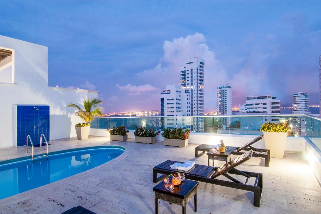 eine Dachterrasse mit Pool und Skyline der Stadt in der Unterkunft Travelers Orange Cartagena in Cartagena de Indias