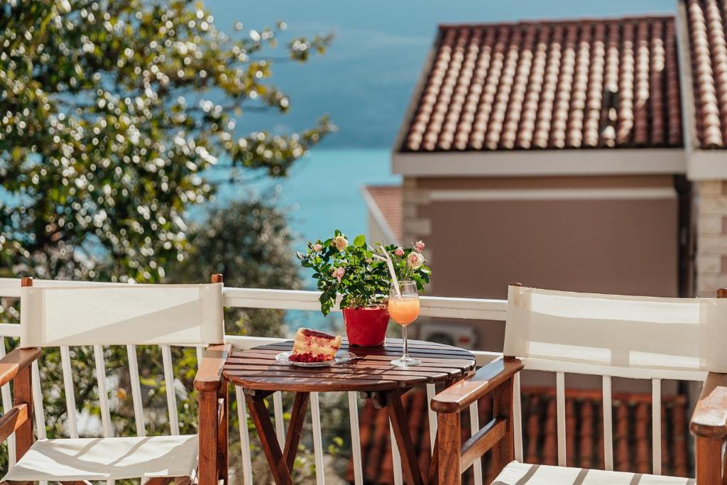 una mesa con una rebanada de tarta y bebidas en un balcón en Apartmani Vico en Herceg-Novi