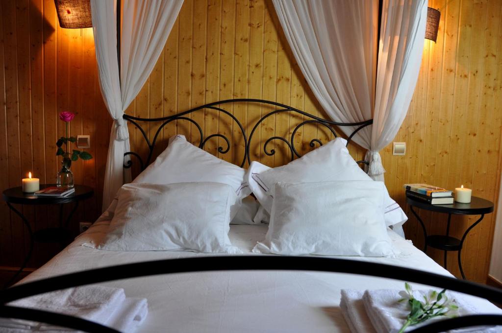 1 dormitorio con 1 cama con sábanas y almohadas blancas en Casa rural La sastreria de Adanero, en Adanero
