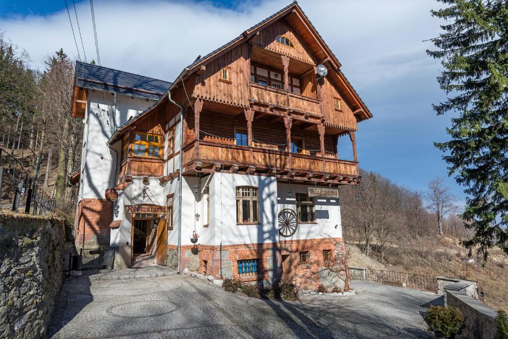 uma grande casa de madeira com uma varanda em Villa Hubertus em Srebrna Góra