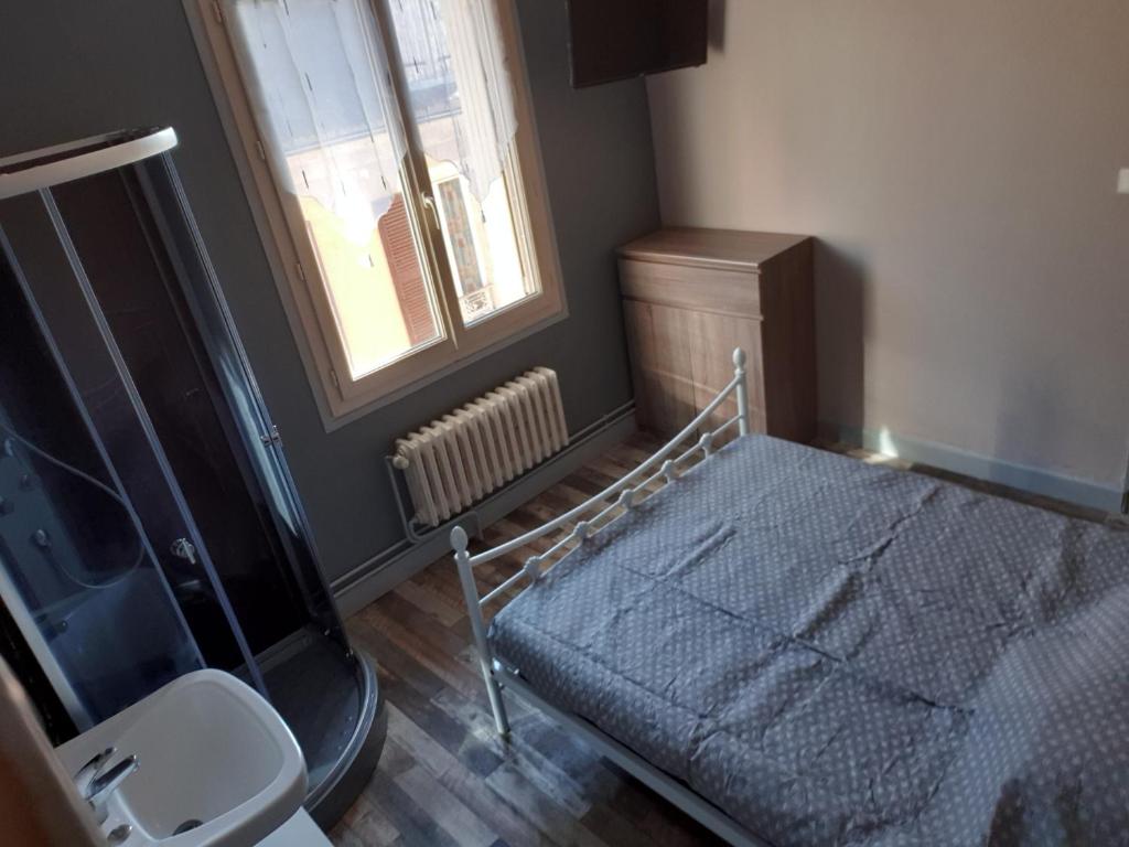 a bedroom with a bed and a sink and a window at La chambre des cht'is in Vayrac