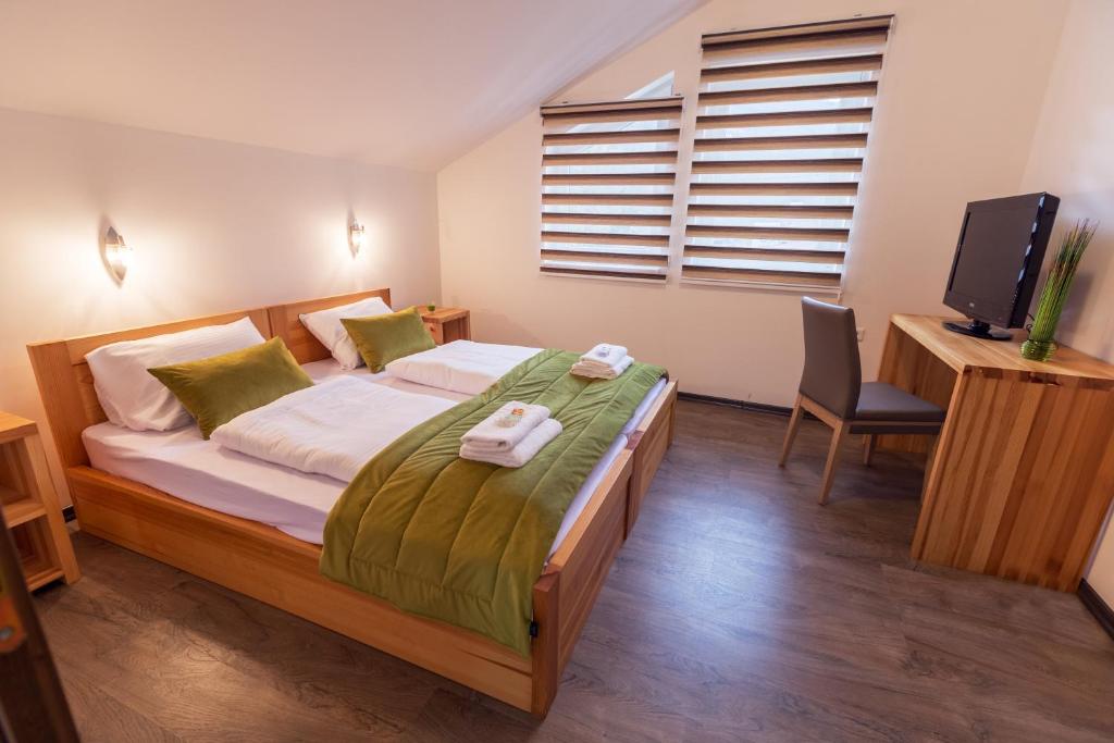- une chambre avec un lit, une télévision et une chaise dans l'établissement Green Villas Tjentiste, à Tjentište