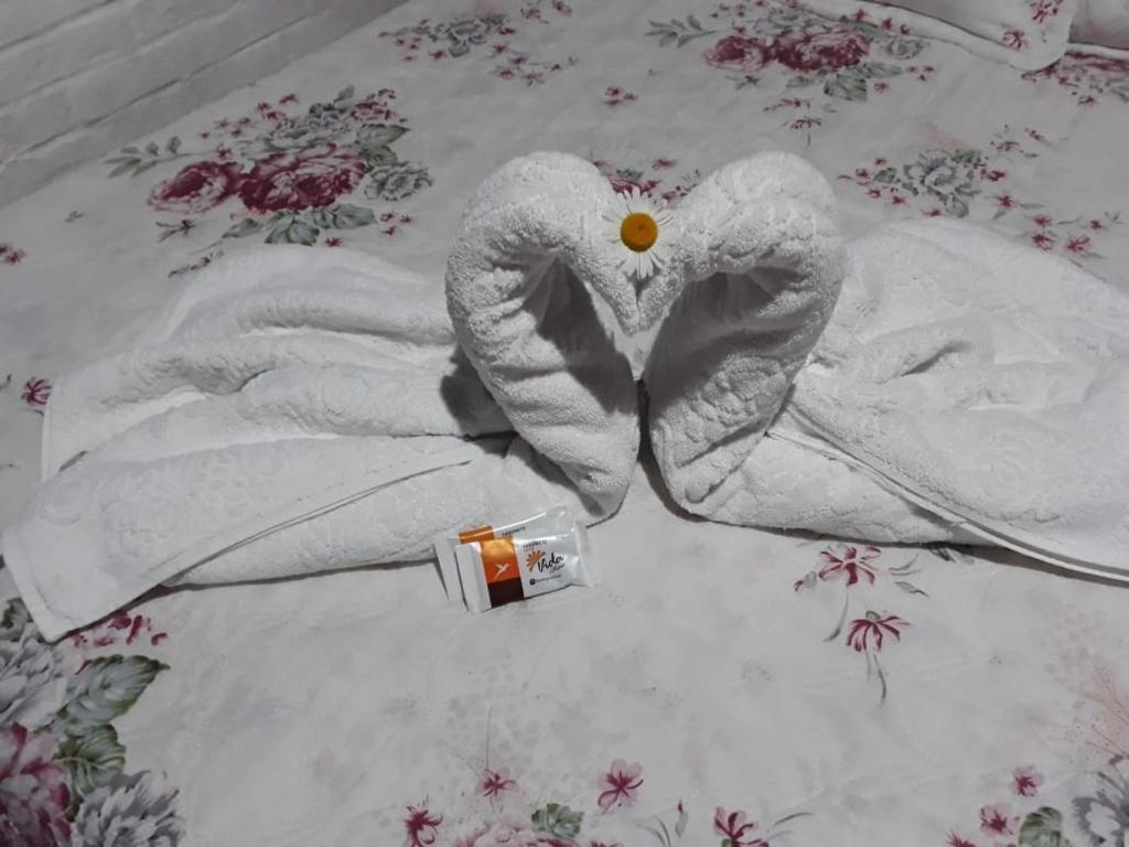 a towel angel laying on a bed with a bottle at Villa de Chino in Monte Verde