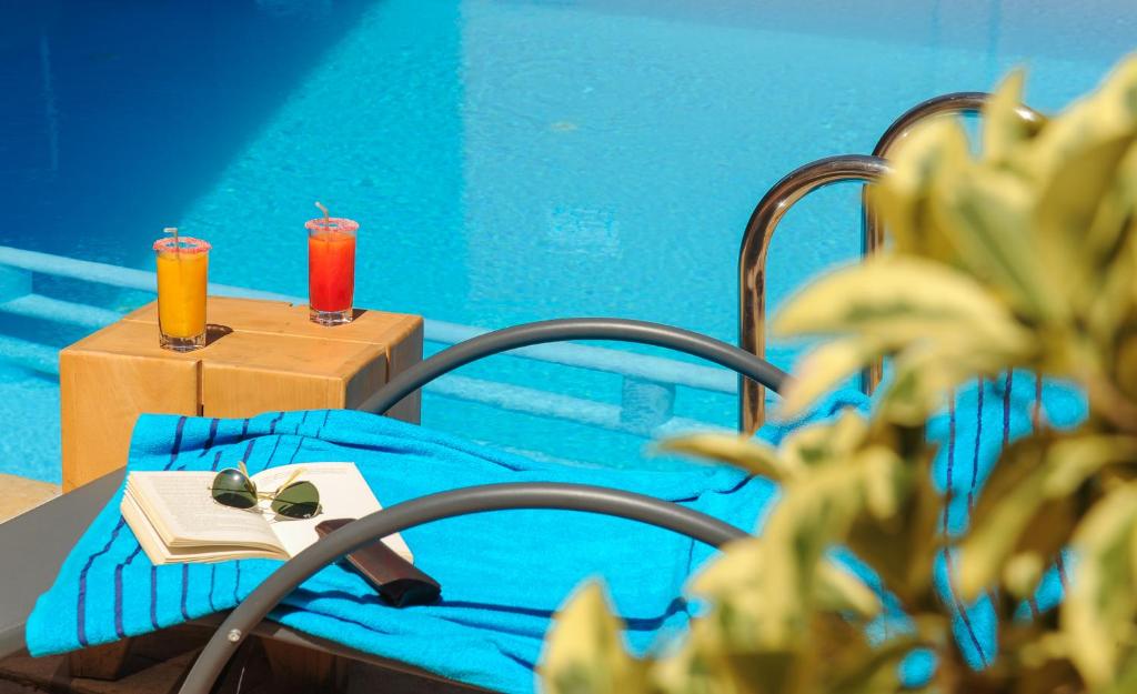 a bedroom with a bed with a book and a table with drinks at Appart-Hotel Amina Resort in Marrakesh