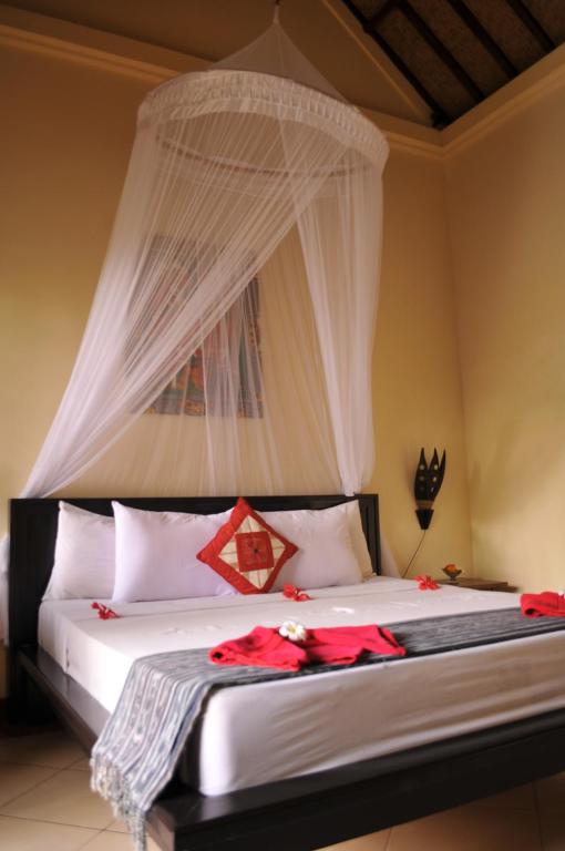 Postel nebo postele na pokoji v ubytování Tirta Sari Bungalow