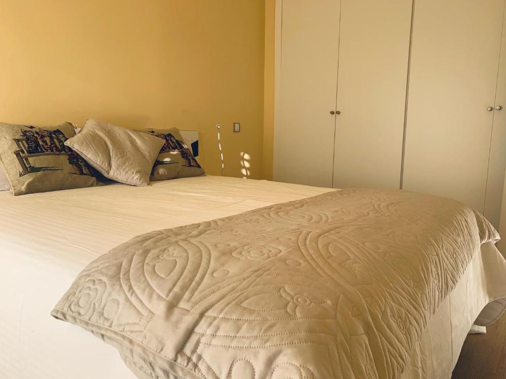 1 dormitorio con 1 cama grande con sábanas blancas en Apartamentos El Retiro de Avellaneda by RetiroRural en Arenas de San Pedro