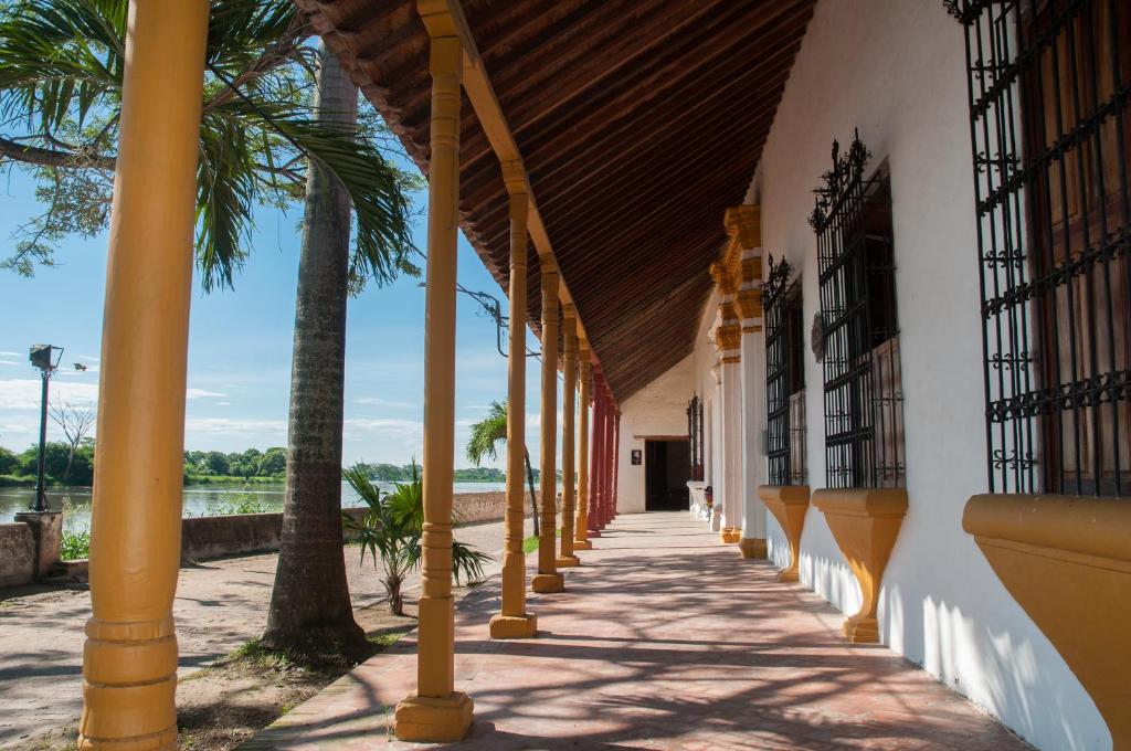 un pasillo con palmeras en el lateral de un edificio en Portal de la Marquesa, en Mompox